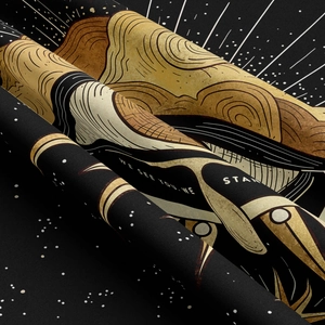 Detail showing the thick golden eye and star pattern printed on black textile fabric
