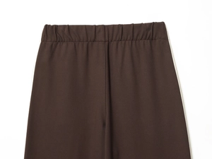 Detailed view of dark brown elastic waist joggers with striped side tape decoration