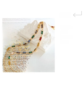 Artistic display of a gold chain bracelet with multicolor rectangular zircon crystals