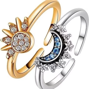 Close-up of adjustable sun and moon rings with gold and silver finishes and zircon stones