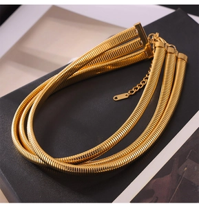 Macro shot of triple-layer gold plated snake chain necklace with adjustable extender