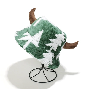 Detailed close-up of fuzzy green and white plush fabric with soft brown 3D reindeer horns