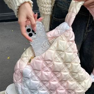 Detail of pink gradient cloud bag showing quilted texture and capacity with a phone