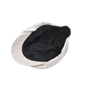 Detail of vintage beige newsboy cap showing black inner lining and elastic band
