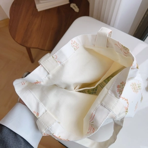 Détail de l'intérieur du sac fourre-tout à fleurs avec une poche plaquée pratique