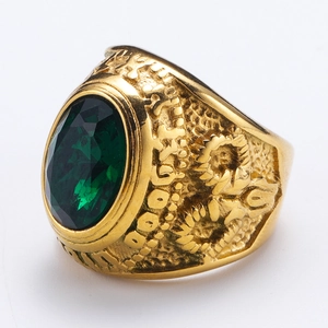 Detalle de anillo punk vintage dorado con gema verde ovalada y relieves grabados