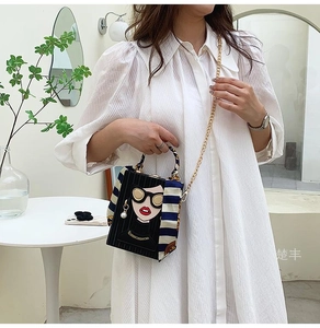 Detail of evening box bag with cartoon face print, silk scarf handle and pearl chain