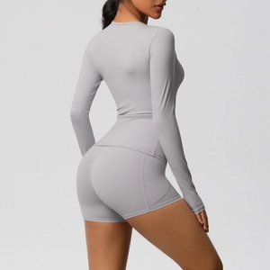 Détail de l'ensemble de yoga gris avec haut à manches longues et short de sport taille haute