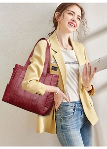 Detailed shot of a burgundy large capacity tote bag worn with a yellow blazer