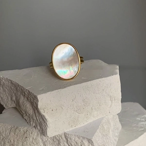 Golden open ring with oval iridescent mother of pearl on textured white stone