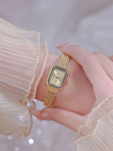 Close-up of golden rectangular quartz watch for women with sparkling crystal bezel