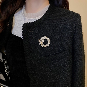Broche fleur perle dorée élégante avec papillon en cristal sur blazer en tweed noir