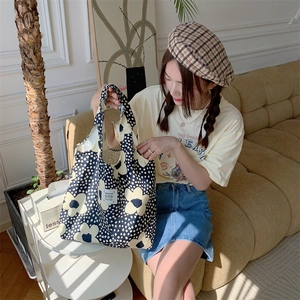 Borsa tote in tela a fiori con pois neri e fiori bianchi in una scena di stile di vita