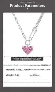 Macro detail of paperclip chain necklace with pink crystal heart pendant and sizing data