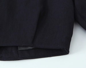 Macro shot of twill fabric texture and neat double-stitched hem on black blazer suit