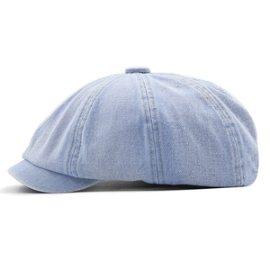 Close-up of light blue denim newsboy cap showing twill texture and eight-panel crown
