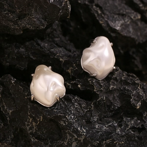 Macro shot of Baroque irregular white pearls on a dark stone background for earrings