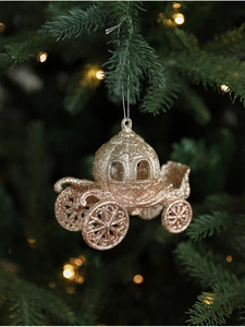 Close-up of champagne gold glitter pumpkin carriage ornament hanging on a Christmas tree
