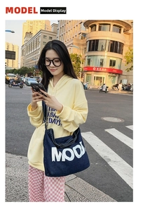 Detailed view of dark blue denim crossbody bag with bold white MOOD lettering
