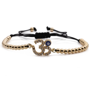 Adjustable evil eye charm bracelet with golden beads, blue zircon, and black woven cord