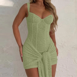 Dettaglio di abito in pizzo verde chiaro con motivi floreali e nodo decorativo in vita