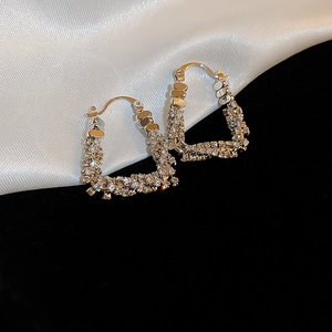 Close-up of U-shaped silver geometric earrings with sparkling zircon inlay and snap closure