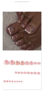 Detailed view of French-style toe nail press-ons with 3D floral and rhinestone accents