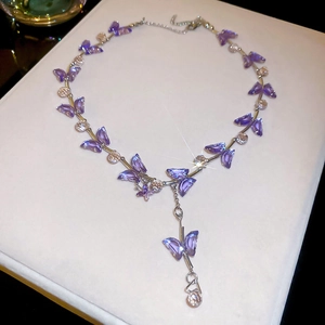 Close-up of butterfly pendant necklace with purple crystals and silver chain details