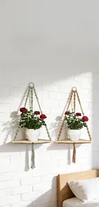 Detail of macrame wall hanging shelf with sage green and caramel cords for plants