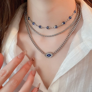 Close-up of triple-layered silver evil eye necklace set with rhinestones on model