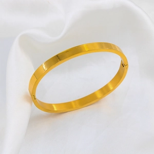 Detailed close-up of high-polish 18k gold plated oval bracelet hinge on white silk