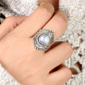 Gros plan d'une bague vintage avec pierre de lune bleue et texture en métal ciselé