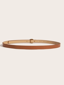 Detailed view of a slim brown leather belt with brass buckle and beige lining for women