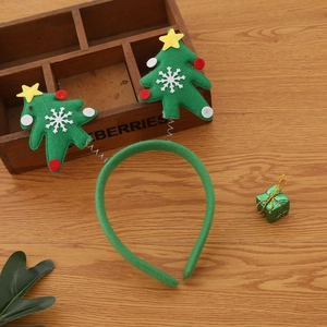 Green felt Christmas tree headband with snow and star decorations on wood background