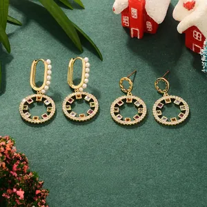 Detail of gold earrings with colorful zircon pendants and pearls in a Christmas setting