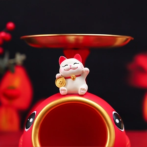 Close-up of red Fortune Cat resin tray with gold dish and copper coins for desk decor