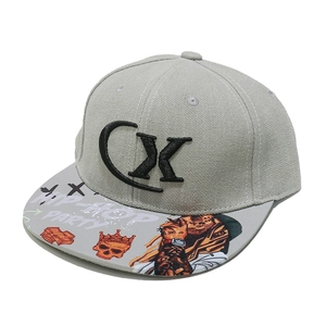 Detail of grey hip-hop cap featuring bold CX embroidery and street graffiti printed brim