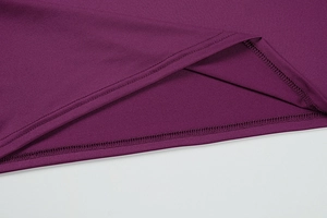 Detailed close-up of double-needle hem stitching on deep purple knit bodycon dress