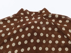 Détail de la blouse en mousseline marron foncé avec pois blancs et col montant chic