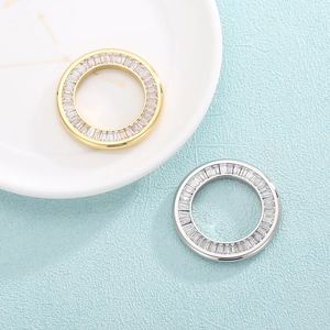 Gold and silver circular pendants with crystal pave inlay on light blue background