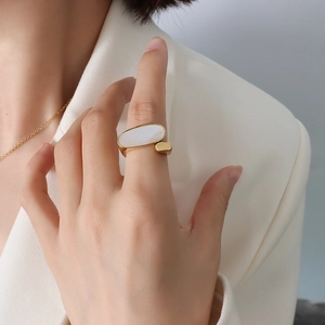 18k gold plated titanium steel ring with oval white shell inlay on a model's hand
