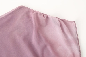 Detail shot of sheer purple mesh fabric texture with elegant pleats and woven patterns