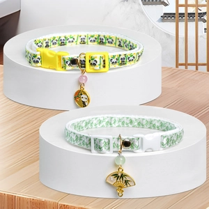 Detail of panda and bamboo print pet collars with decorative metal pendants and buckles