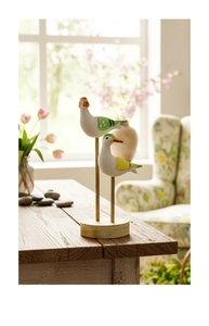 Detailed macro view of two minimalist wooden sea bird figurines on a sturdy round base