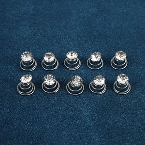 Close-up of ten silver spiral hair pins with rhinestone studs on navy background