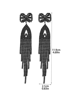 Detail view of black bow earrings with long fringe and zircon pavé detailing