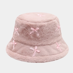 Detail of pink faux rabbit fur bucket hat featuring delicate satin ribbon bow accents