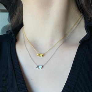 Detailed view of layered S925 silver heart and circle pendants in gold and silver finish
