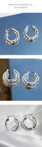 Macro detail of silver hoop earrings with inlaid white pearls on elegant silk fabric