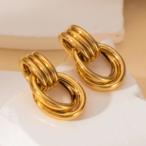 Polished golden stainless steel triple-linked hoop earrings on a stone display